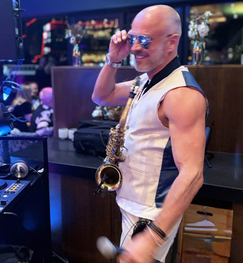 Paul Martyn playing saxophone at the DJ booth